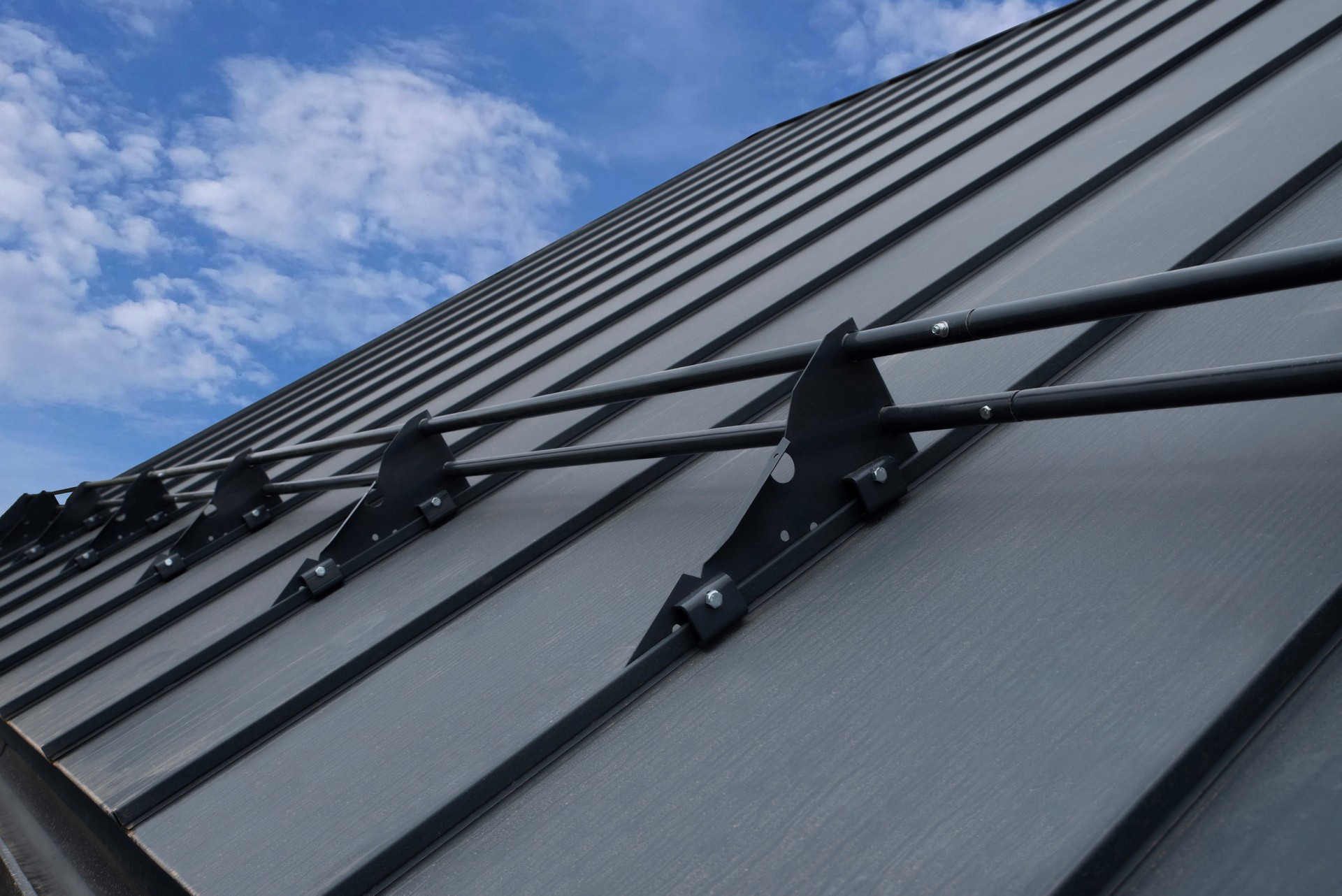 Snow guards for standing seam metal roofs